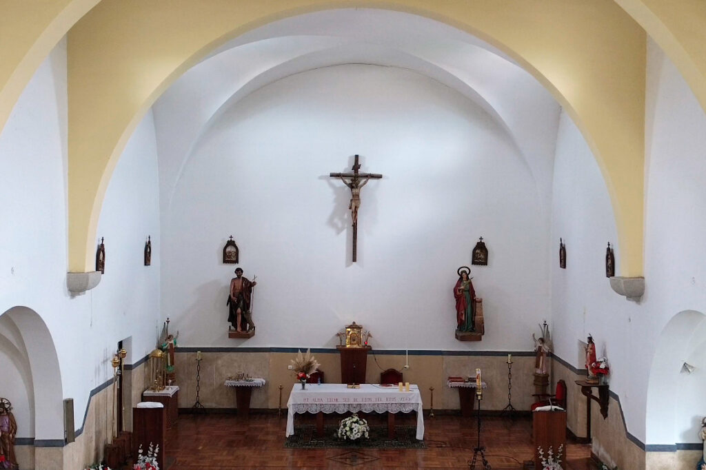 Sobrio interior de la iglesia de San Juan Bautista de Hérmedes de Cerrato. La cabecera la preside un cristo crucificado, flanqueado por imagnes de San Juan Bautista y Santa Bárbara.