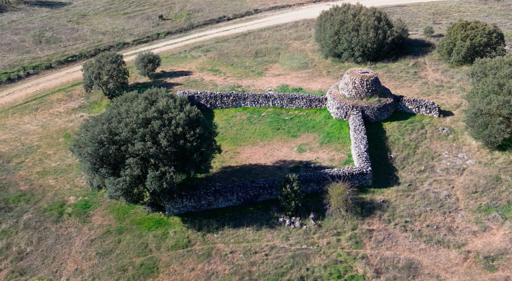 Chozo de pastor de forma circular con un corral rectangular. Todo ello realizado en piedra seca.