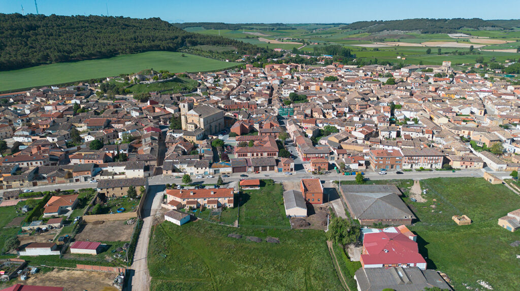 Panorámica aérea de Astudillo, con la iglesia de Santa Eugenia en primer término. Tras ella el cerro del Castillo con las bodegas.