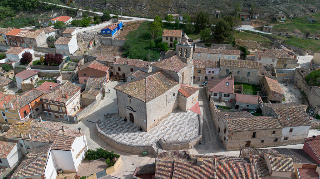 Panorámica aérea de la iglesia de San Miguel Arcángel de Hornillos de Cerrato. Al fondo el barrio de bodegas.
