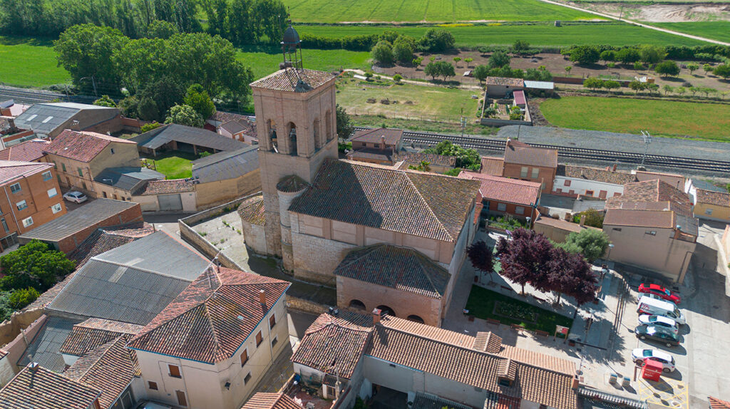 Panorámica aérea de la iglesia de San Mamés de Magaz de Pisuerga. Inmediatamenta tras ella se encuentran las vías del tren.