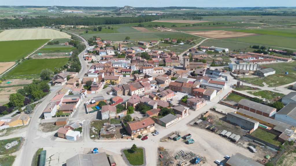 Panorámica aéra de Soto de Cerrato, rodeado por campos de cultivo. Al fondo, una línea de árboles marca la vega del Pisuerga.