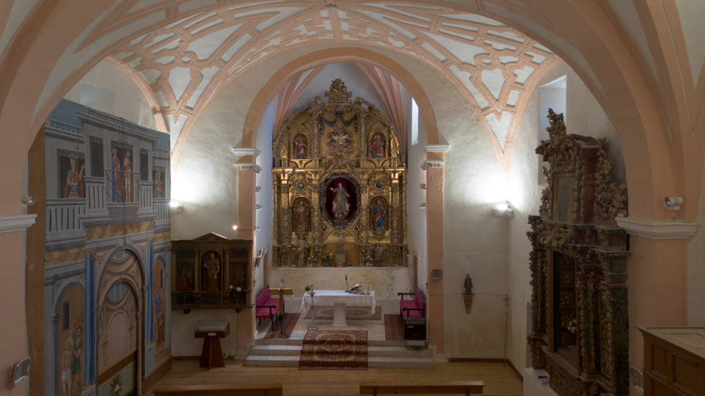 Interior de la iglesia de la Asunción de Reinoso de Cerrato. Al fondo se encuentra el retablo mayor barroco decorado con pan de oro y presidido por la imagen de Asunción de la Virgen. En el lateral izquiero destaca un retablo pintado.