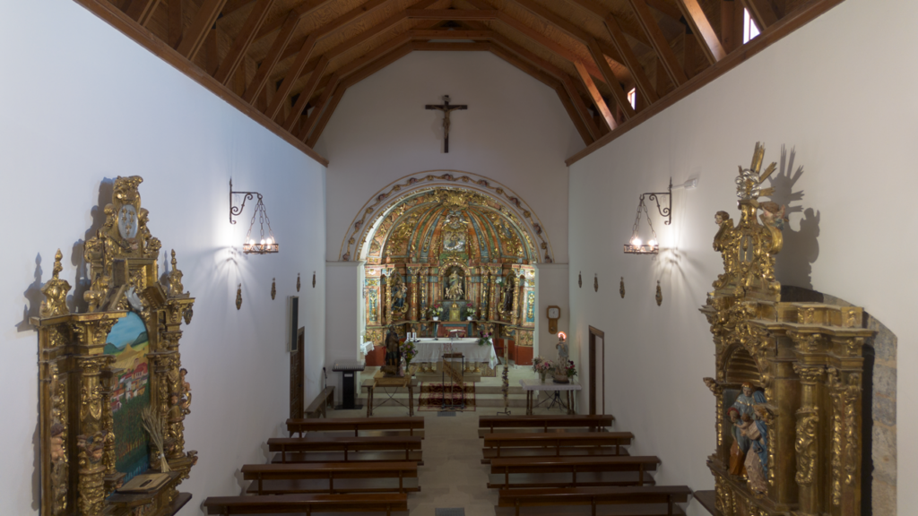 Interior de la iglesia de la Asunción de Soto de Cerrato. Al fondo el retablo mayor barroco profusamente decorado presidido por una imagen de la Asunción de la Virgen.
