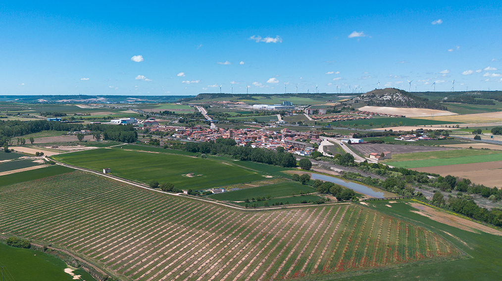 Panorámica aérea de Magaz de Pisuerga. En primer término el río y al fondo el cerro con las ruinas del castillo.