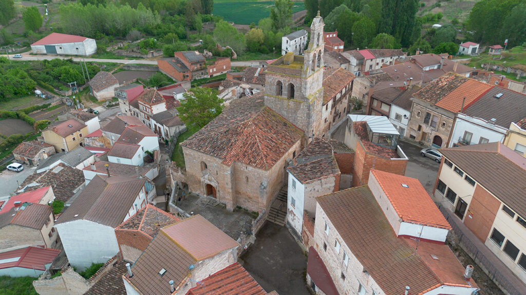 Panorámica aérea de la iglesia de San Martín de Tours, ubicada al filo de la ladera y encajonada entre las edificaciones circundantes. Destaca su torre rematada por una espadaña.