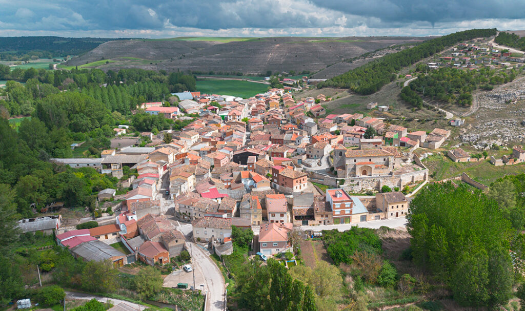 Panorámica aérea de Cobos de Cerrato. En primer término destaca la iglesia y al fondo el barrio de bodegas en un cerro que domina la villa.