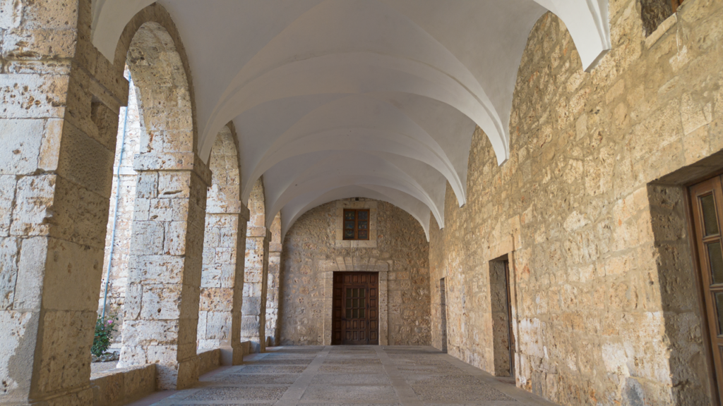 Una de las galerías del claustro del Monasterio de San Isidro de Dueñas. Realizado en piedra, con arcos de medio punto y bóvedas enyesadas.