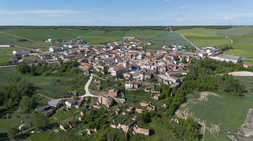 Panorámica aérea de Tabanera de Cerrato, rodeado por campos de cultivo. La iglesia despunta sobre el resto de edificaciones de la villa.