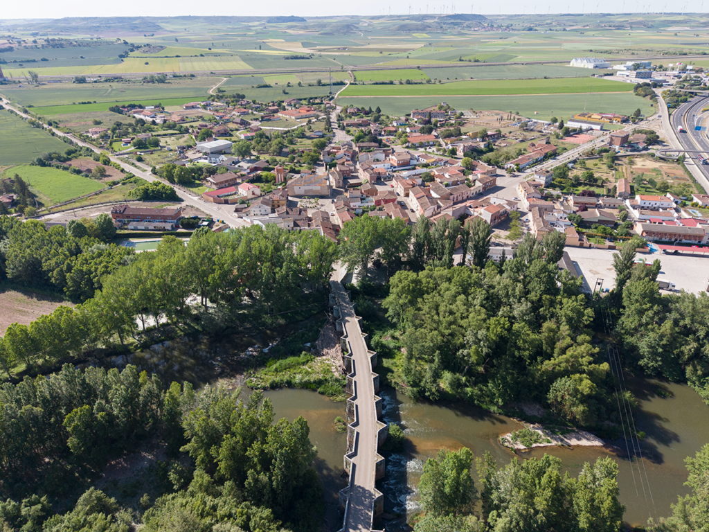 Panorámica aérea de Quintana del Puente. En primer término el puente sobre el Pisuerga, del siglo XVI. Al fondo campos de cultivo.
