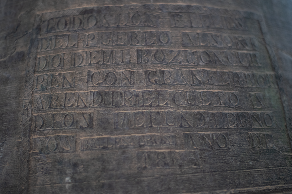 Detalle de las campanas de la iglesia de la Asunción de Reinoso de Cerrato. Se puede leer "Todos los fieles del pueblo añ sonido de mi voz concurren con gran fervor a rendir el culto a Dios. Me fundieron los ballesteros. Año de 1885".