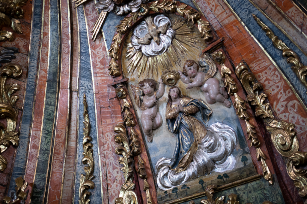 Detalle del retablo mayor de la iglesia de Asunción, con un relieve que representa al coronación de la virgen por dos ángeles.