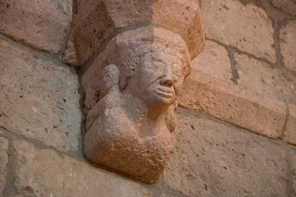 Ménsula decorada con el busto de un hombre de pelo rizado en el interior de la iglesia de San Martín de Tours de Espinosa de Cerrato