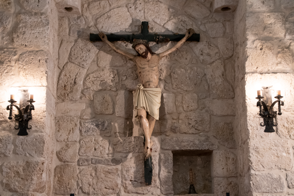 Cristo crucificado gótico expuesto en uno de los muros de la Iglesia de Nuestra Señora de la Asunción de Villaviudas.
