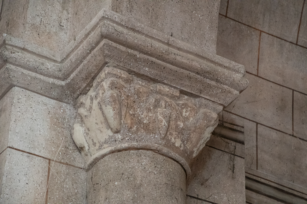 Capitel románico decorado con piñas que sostiene uno de los lados del arco de la cabecera de la iglesia de San Julián y Santa Basilisa de Villaconancio