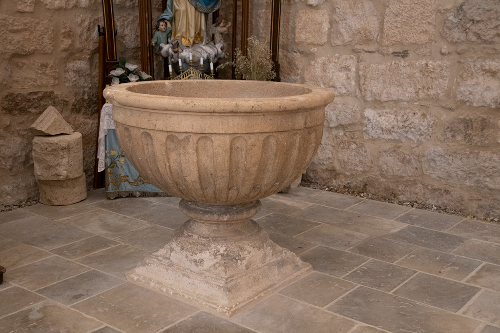Pila bautismal de la iglesia de San Esteban de Quintana del Puente. Es renacentista y presenta una decoración sencilla de acanaladuras.