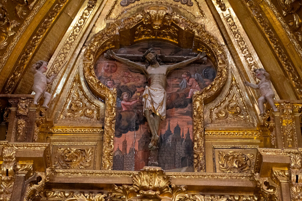 Atrio del retablo mayor barroco de la iglesia de Santa Cecilia de Herrera de Valdecañas. En él se ha encastrado un Cristo crucificado anterior y se le ha añadido un fondo pintado que representa Jerusalén.