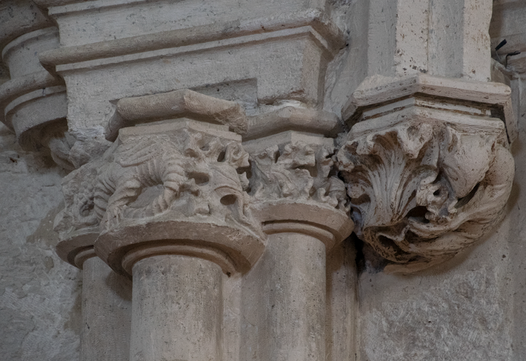 Detalle de los capiteles góticos de las pilastras, decorados con motivos vegetales y animales entrelazados.