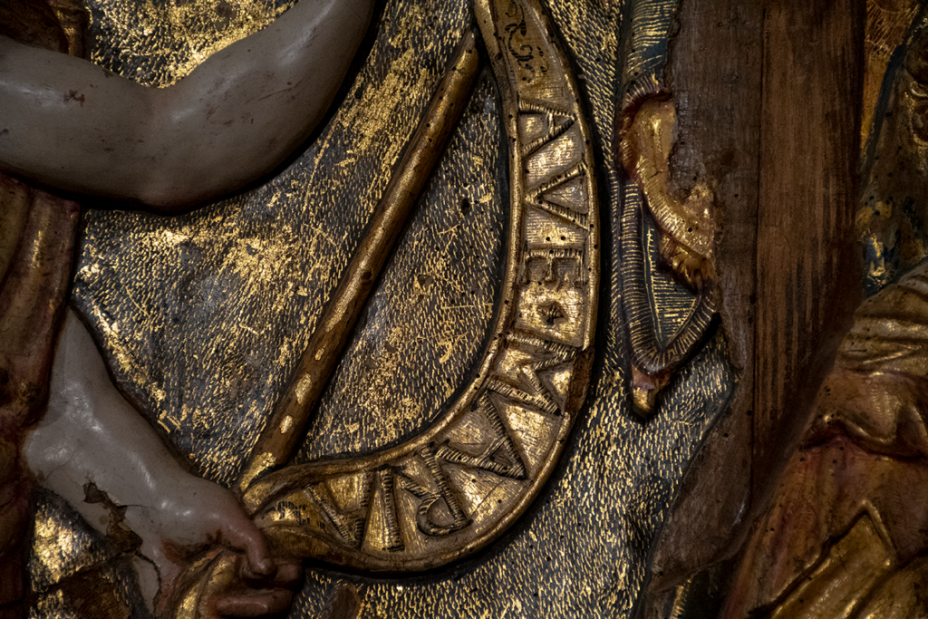 Detalle del retablo renacentista de la iglesia de Nuestra Señora de la Asunción de Melgar de Yuso. Es un estandarte en el que se puede leer "Ave Maria".