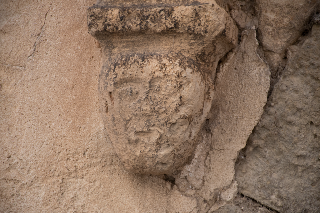 Detalle de una portada de una casa blasonada de Torquemada, Ménsula decorada con una cabeza humana.