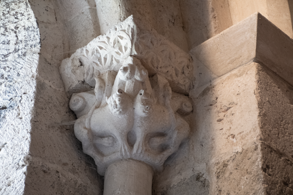 Capitel románico de uno de los arcos de las ventanas del interior de la iglesia de San Juan Bautista de Valdeolmillos. Representa a dos animales enfrentados, posiblemente dos leones.