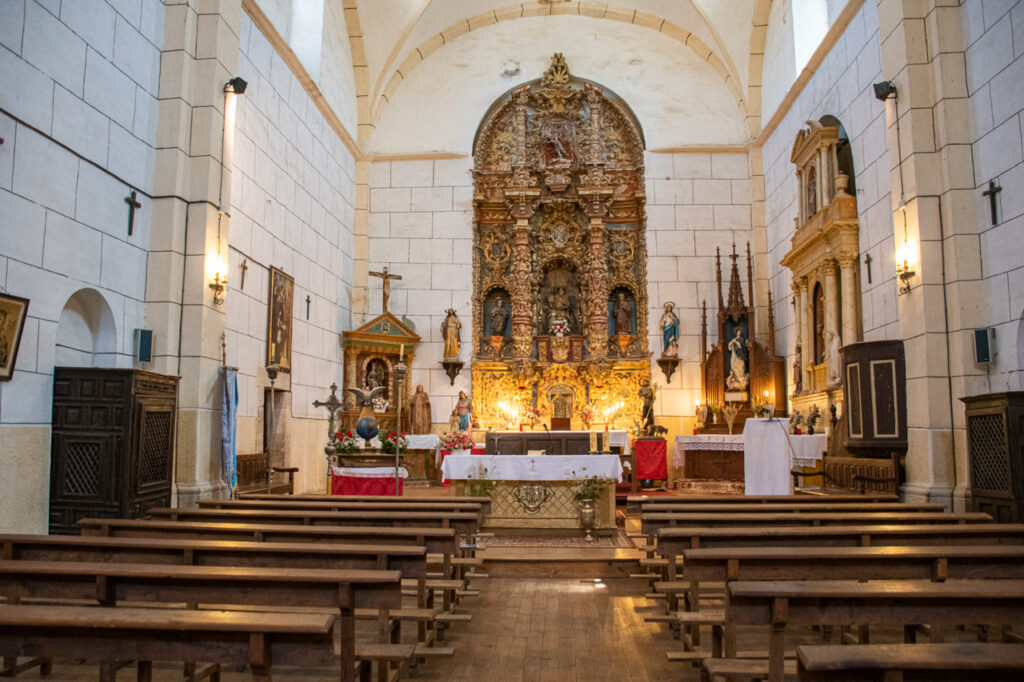 Cabecera de la iglesia de San Martín de Tours de Valbuena de Pisuerga, presidida por el retablo mayor barroco y con otros retablos menores a ambos lados de la nave.