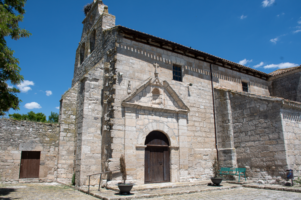Exterior de la iglesia de San Esteban de Villodrigo, con su portada de acceso con tímpano y una hornacina vacía.
