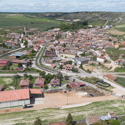 Panorámica aérea general de Villamediana. En primer término, el inicio de la avenida principal ajardinada que recorre el centro de la localidad, y al fondo los páramos, en cuyas laderas de pueden apreciar las bocas de las minas de yeso.