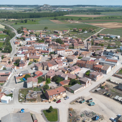 Panorámica aéra de Soto de Cerrato, rodeado por campos de cultivo. Al fondo, una línea de árboles marca la vega del Pisuerga.