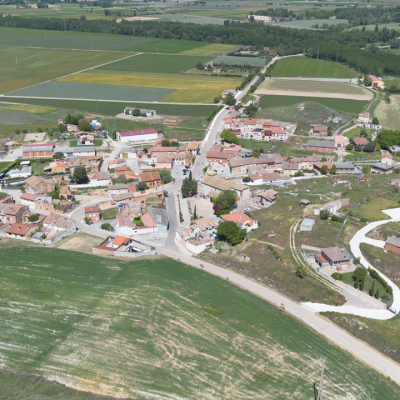 Panorámica aérea de Reinoso de Cerrato. En primer termino la iglesia y el barrio de bodegas y al fondo la línea de árboles marca el curso del río Pisuerga.