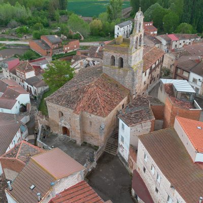 Panorámica aérea de la iglesia de San Martín de Tours, ubicada al filo de la ladera y encajonada entre las edificaciones circundantes. Destaca su torre rematada por una espadaña.