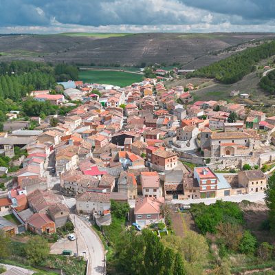 Panorámica aérea de Cobos de Cerrato. En primer término destaca la iglesia y al fondo el barrio de bodegas en un cerro que domina la villa.