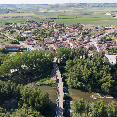 Panorámica aérea de Quintana del Puente. En primer término el puente sobre el Pisuerga, del siglo XVI. Al fondo campos de cultivo.